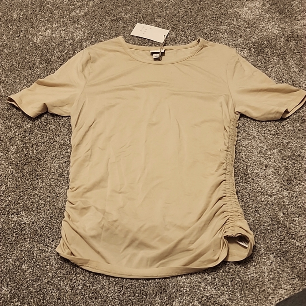 Beige top with singed sides. Size small. Never been worn.